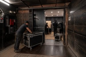 A team of workers handling equipment cases in a loading bay area.