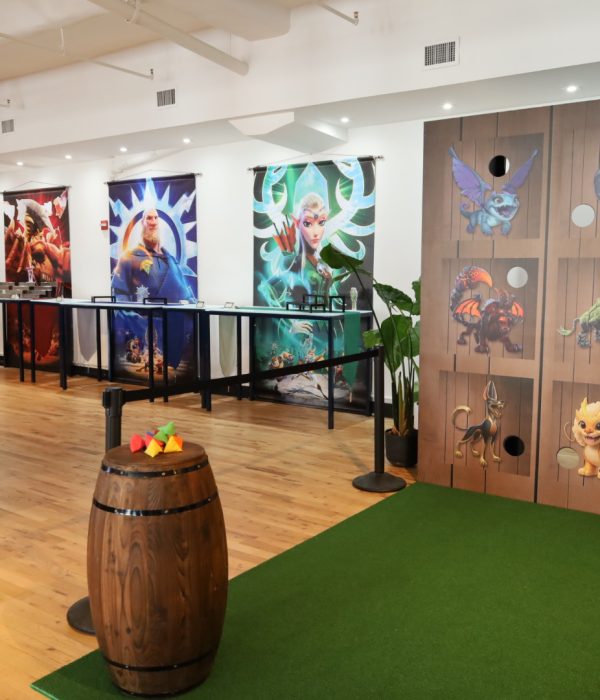 A brightly decorated game room featuring colorful banners and a playful wooden game wall.
